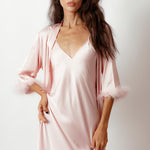 a model wearing silky pink robe with feather trimmed cuffs front