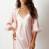 a model wearing silky pink robe with feather trimmed cuffs front