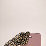 Leopard print silk eye mask next to a ROSEMO pink gift box 