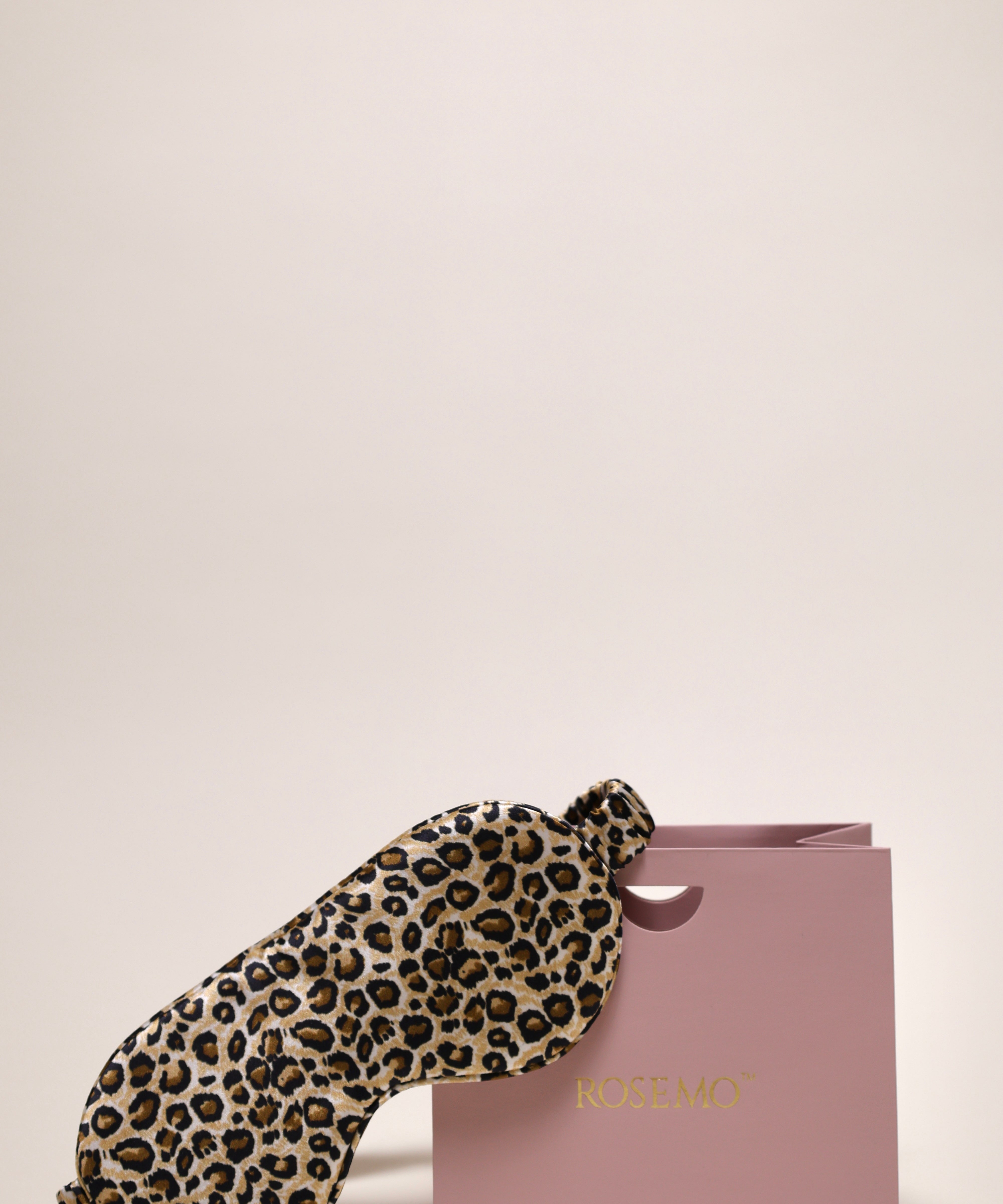 Leopard print silk eye mask next to a ROSEMO pink gift box 