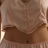 Light pink satin lingerie set with buttons and lace details.