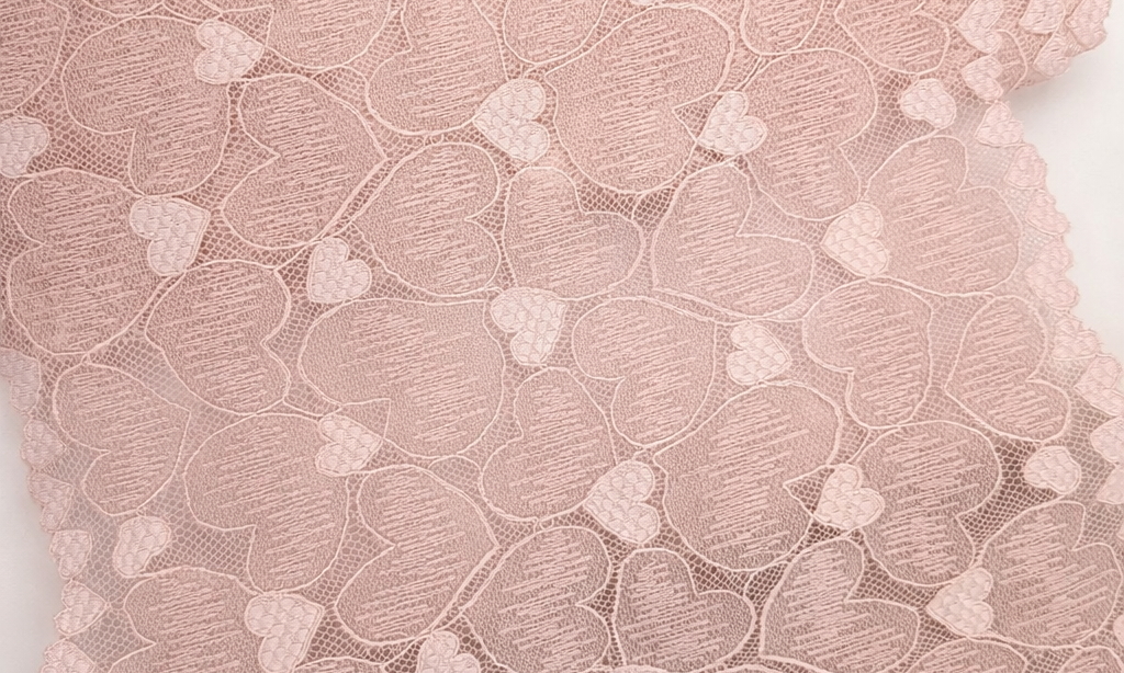 Close-up of pink lace fabric with a heart pattern