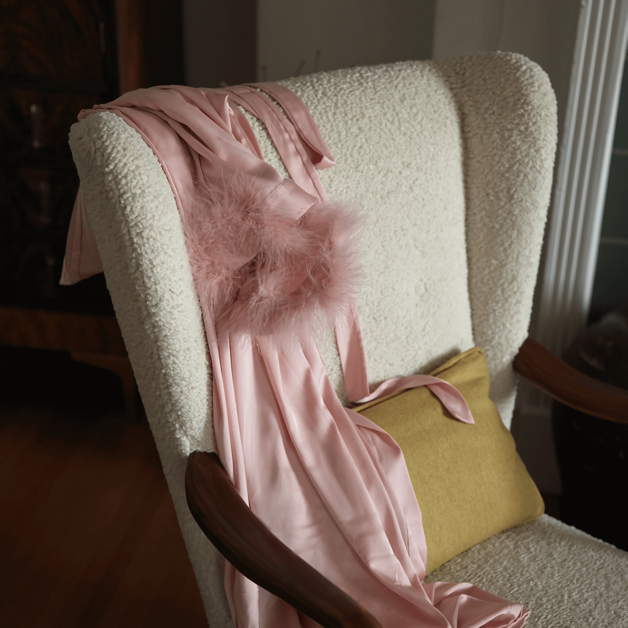 Pink satin lingerie robes on a couch
