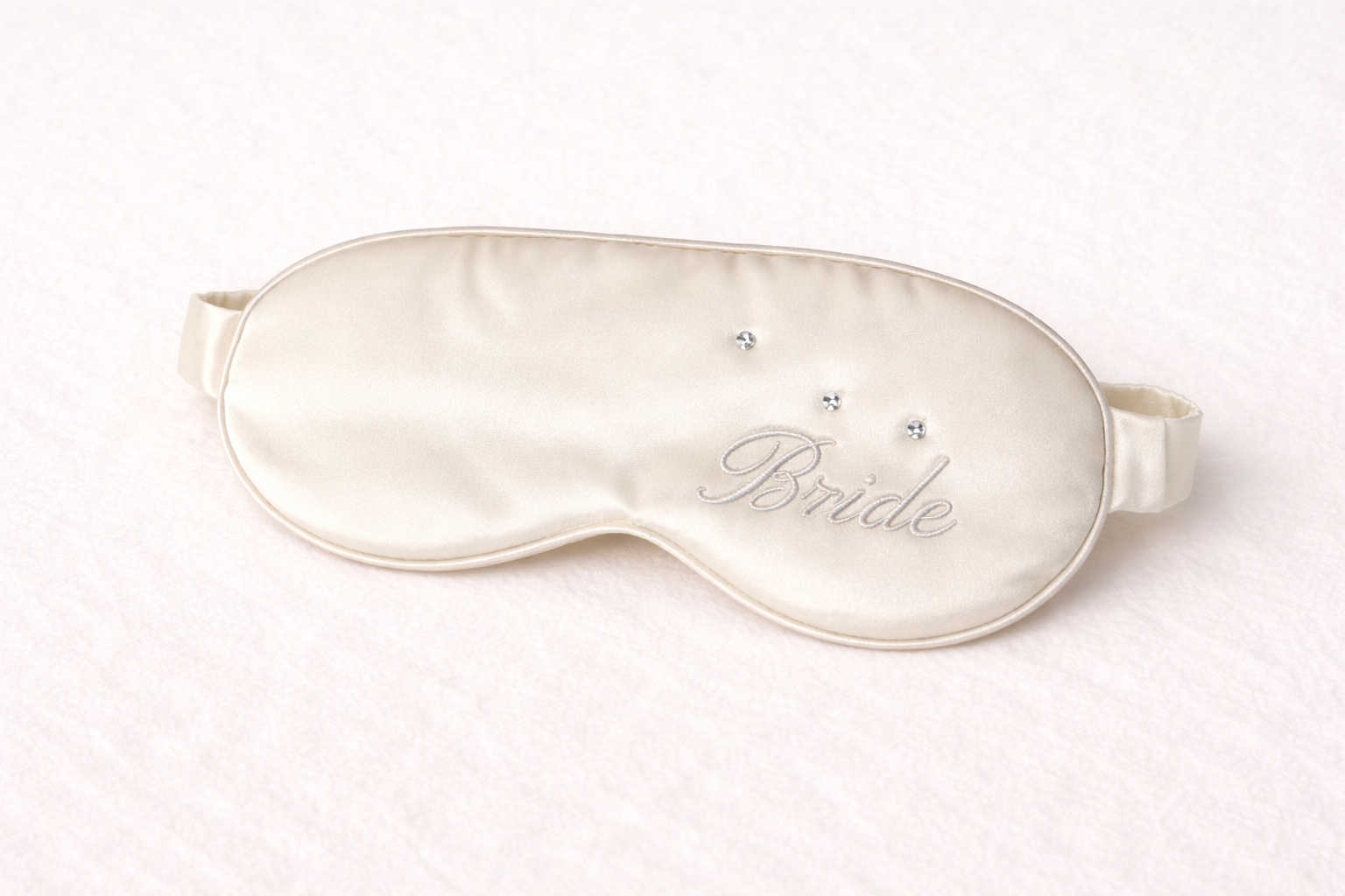 Silk sleep mask with 'Bride' embroidery on a white background