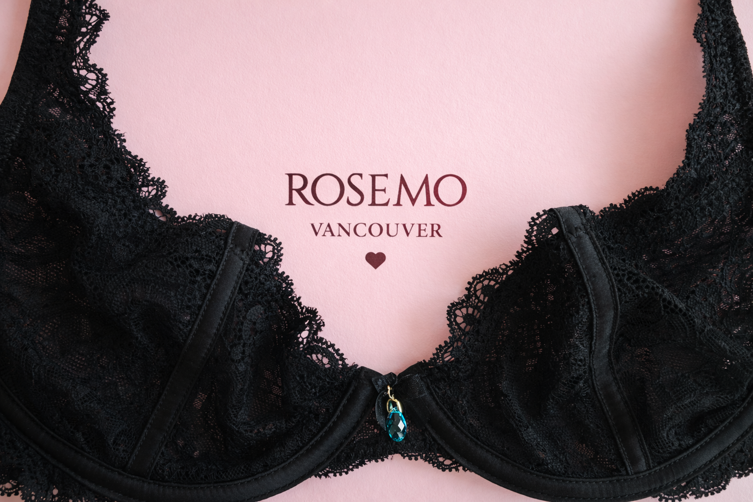 Black lace bra on a pink background with 'ROSEMO Vancouver' branding.