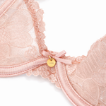 Close-up of a pink bra with charm details on a white background