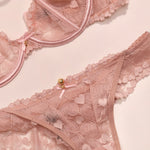 Pink lace lingerie set on a light pink background