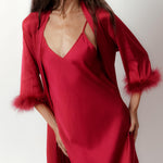 a model wearing silky red robe with feather trimmed cuffs front