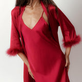 a model wearing silky red robe with feather trimmed cuffs front