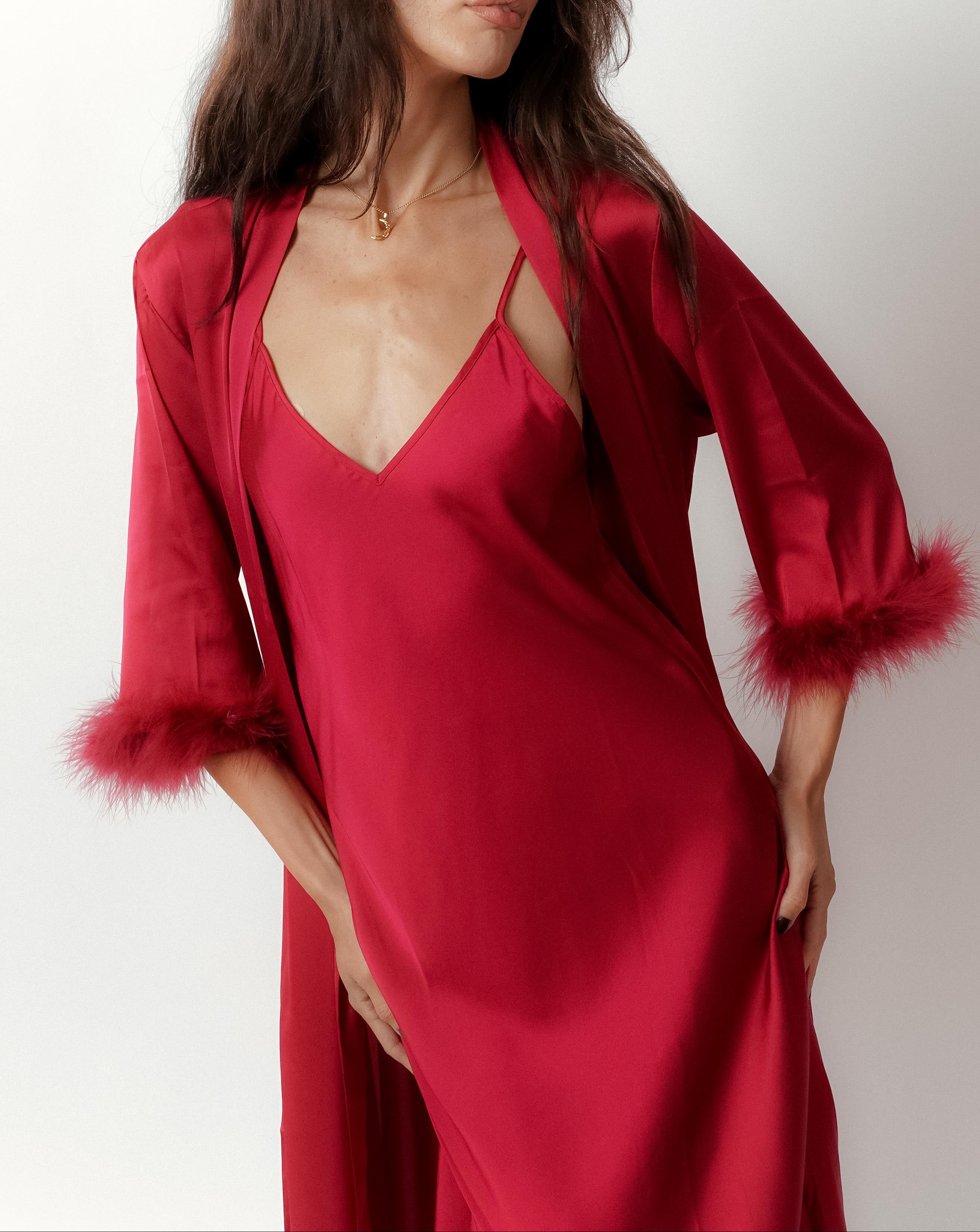 a model wearing silky red robe with feather trimmed cuffs front