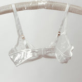 Clear plastic bra on a hanger against a white background